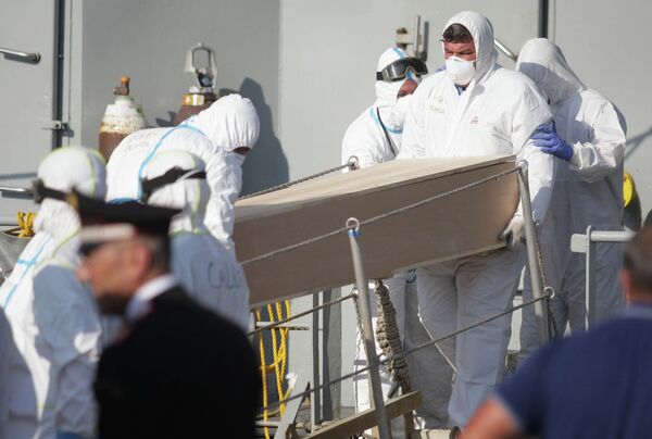 Rescuers carry a coffin off the Irish military vessel Naimh after its arrival in the port of Palermo on August 6, 2015, with 367 survivors aboard and 25 coffins, following a rescue operation at sea of a boat carrying over 600 migrants that capsized in the Mediterranean Sea off the Libyan coast. Rescuers carry a coffin off the Irish military vessel Naimh after its arrival in the port of Palermo on August 6, 2015, with 367 survivors aboard and 25 coffins, following a rescue operation at sea of a boat carrying over 600 migrants that capsized in the Mediterranean Sea off the Libyan coast. - Sputnik International