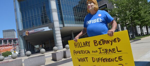 Protestor Bob Kunst of Miami, wears a Hillary Clinton mask while demonstrating outside of the Quicken Loans Arena on August 5, 2015 in Cleveland, Ohio Protestor Bob Kunst of Miami, wears a Hillary Clinton mask while demonstrating outside of the Quicken Loans Arena on August 5, 2015 in Cleveland, Ohio - Sputnik International