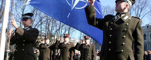 Latvian officers stand guard during the NATO flag rising ceremony in front of the Presidents castle in Riga Latvian officers stand guard during the NATO flag rising ceremony in front of the Presidents castle in Riga - Sputnik International