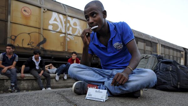 An immigrant from India rolls a cigarette at Gevgelija railway station, Macedonia August 19, 2015 - Sputnik International
