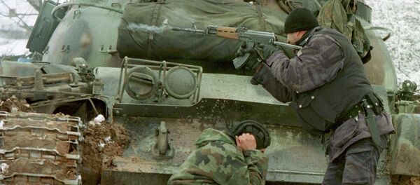 A Yugoslav special forces policeman shoots his rifle at opposing Kosovo Liberation Army forces as a Yugoslav Army tank driver covers his ears after coming under fire Tuesday Feb. 23, 1999 in the village of Bukos - Sputnik International