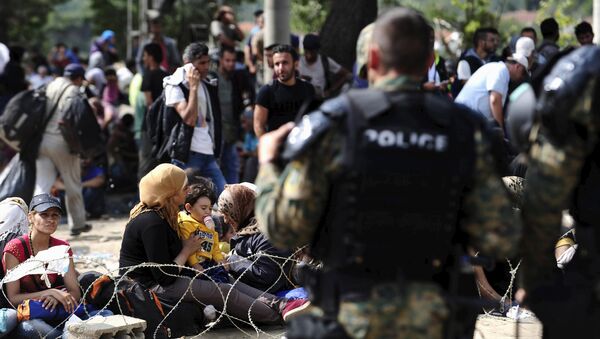 Macedonian special policemen guard the border as more than a thousand immigrants wait at the border line of Macedonia and Greece to enter Macedonia near the Gevgelija railway station August 21, 2015 - Sputnik International