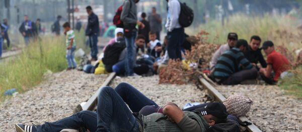 Migrants rest while waiting to pass the Greek-Macedonian border, guarded by Macedonian police near the town of Idomeni, northern Greece, on August 21, 2015 Migrants rest while waiting to pass the Greek-Macedonian border, guarded by Macedonian police near the town of Idomeni, northern Greece, on August 21, 2015 - Sputnik International