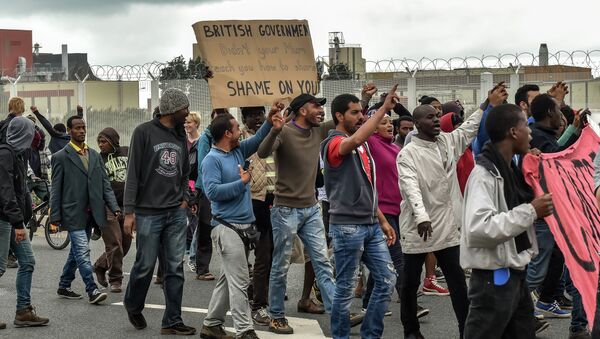 Illegal migrants demonstrate against British government, on August 20, 2015 in Calais, on the occasion of the visit of Britain's Home Secretary visit to Calais to sign a deal aimed at alleviating the migrant crisis - Sputnik International