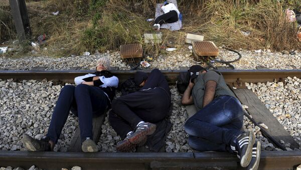 Migrants rest on a railway track at the Greek-Macedonian border, August 21, 2015 - Sputnik International