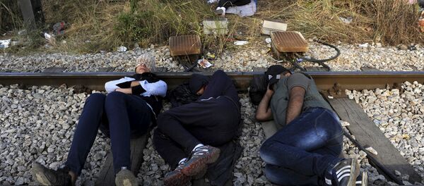 Migrants rest on a railway track at the Greek-Macedonian border, August 21, 2015 - Sputnik International