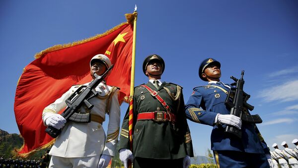 Officers and soldiers of China's People's Liberation Army hold a flag and weapons during a training session for a military parade to mark the 70th anniversary of the end of World War Two, at a military base in Beijing, China, August 22, 2015 - Sputnik International