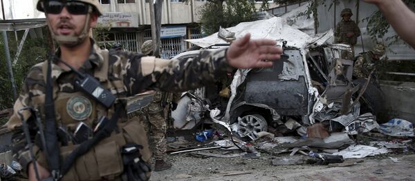 Members of Afghan security forces keep watch in front of a damaged car that belongs to foreigners after a bomb blast in Kabul, Afghanistan August 22, 2015. - Sputnik International