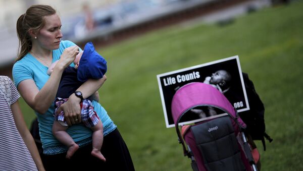 A woman holds her baby as she attends a Women Betrayed Rally to Defund Planned Parenthood at Capitol Hill in Washington. (File) - Sputnik International