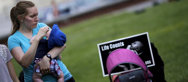 A woman holds her baby as she attends a Women Betrayed Rally to Defund Planned Parenthood at Capitol Hill in Washington. (File) A woman holds her baby as she attends a Women Betrayed Rally to Defund Planned Parenthood at Capitol Hill in Washington. (File) - Sputnik International