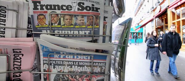 People are seen walking behind French daily newspapers displayed at a news kiosk in Paris. (File) People are seen walking behind French daily newspapers displayed at a news kiosk in Paris. (File) - Sputnik International