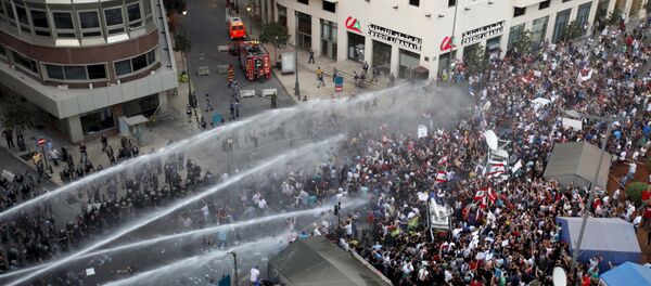 Lebanese protesters are sprayed with water during a protest against corruption and rubbish collection problems near the government palace in Beirut Lebanese protesters are sprayed with water during a protest against corruption and rubbish collection problems near the government palace in Beirut - Sputnik International