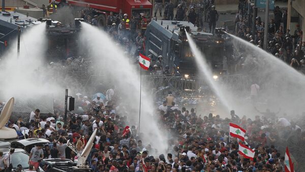 Lebanese protesters are sprayed with water during a protest against corruption and against the government's failure to resolve a crisis over rubbish disposal, near the government palace in Beirut, Lebanon August 23, 2015 - Sputnik International