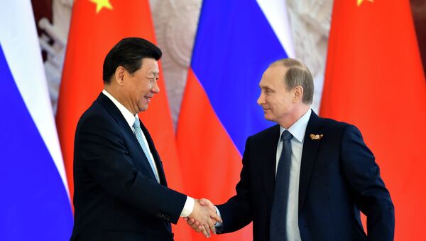 Russian President Vladimir Putin (R) shakes hands with his Chinese counterpart Xi Jinping - Sputnik International