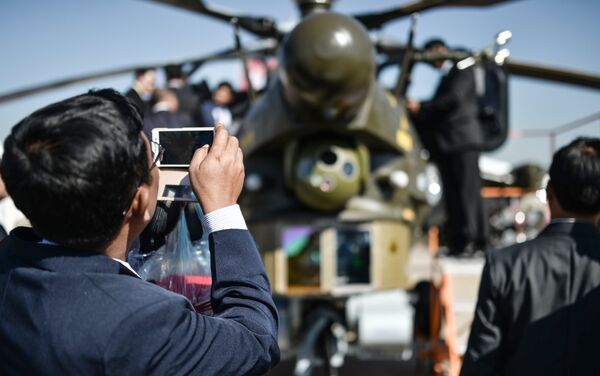 Visitors look at a Mil Mi-28 NE attack helicopter during the International Aerospace Salon MAKS 2015 - Sputnik International