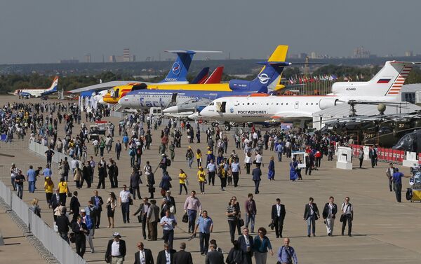 Visitors walk along a row of planes and helicopters on display at the MAKS International Aviation and Space Salon in Zhukovsky, outside Moscow, Russia, August 25, 2015 - Sputnik International