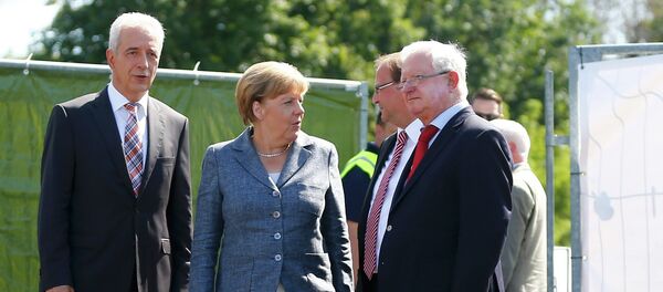Saxony State Prime Minister Stanislaw Tillich, German Chancellor Angela Merkel, major Juergen Opitz and President of the German Red Cross Rudolf Seiters (LtoR) arrive to visit an asylum seekers accomodation facility in the eastern German town of Heidenau near Dresden, August 26, 2015 where last week more than 30 police were injured in clashes, when a mob of several hundred people pelted officers with bottles and fireworks Saxony State Prime Minister Stanislaw Tillich, German Chancellor Angela Merkel, major Juergen Opitz and President of the German Red Cross Rudolf Seiters (LtoR) arrive to visit an asylum seekers accomodation facility in the eastern German town of Heidenau near Dresden, August 26, 2015 where last week more than 30 police were injured in clashes, when a mob of several hundred people pelted officers with bottles and fireworks - Sputnik International