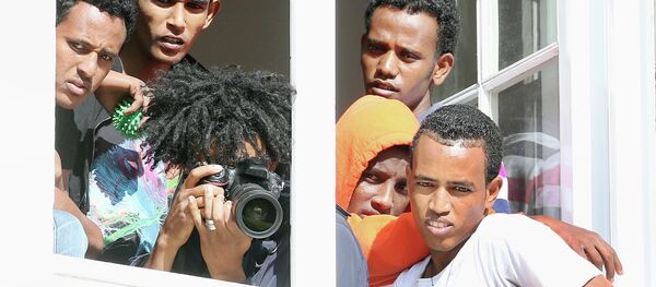 Asylum seekers stand at a window as they watch German president Joachim Gauck visiting the asylum-seekers home in Berlin-Wilmersdorf a in Berlin, Germany, Wednesday Aug. 26, 2015 Asylum seekers stand at a window as they watch German president Joachim Gauck visiting the asylum-seekers home in Berlin-Wilmersdorf a in Berlin, Germany, Wednesday Aug. 26, 2015 - Sputnik International