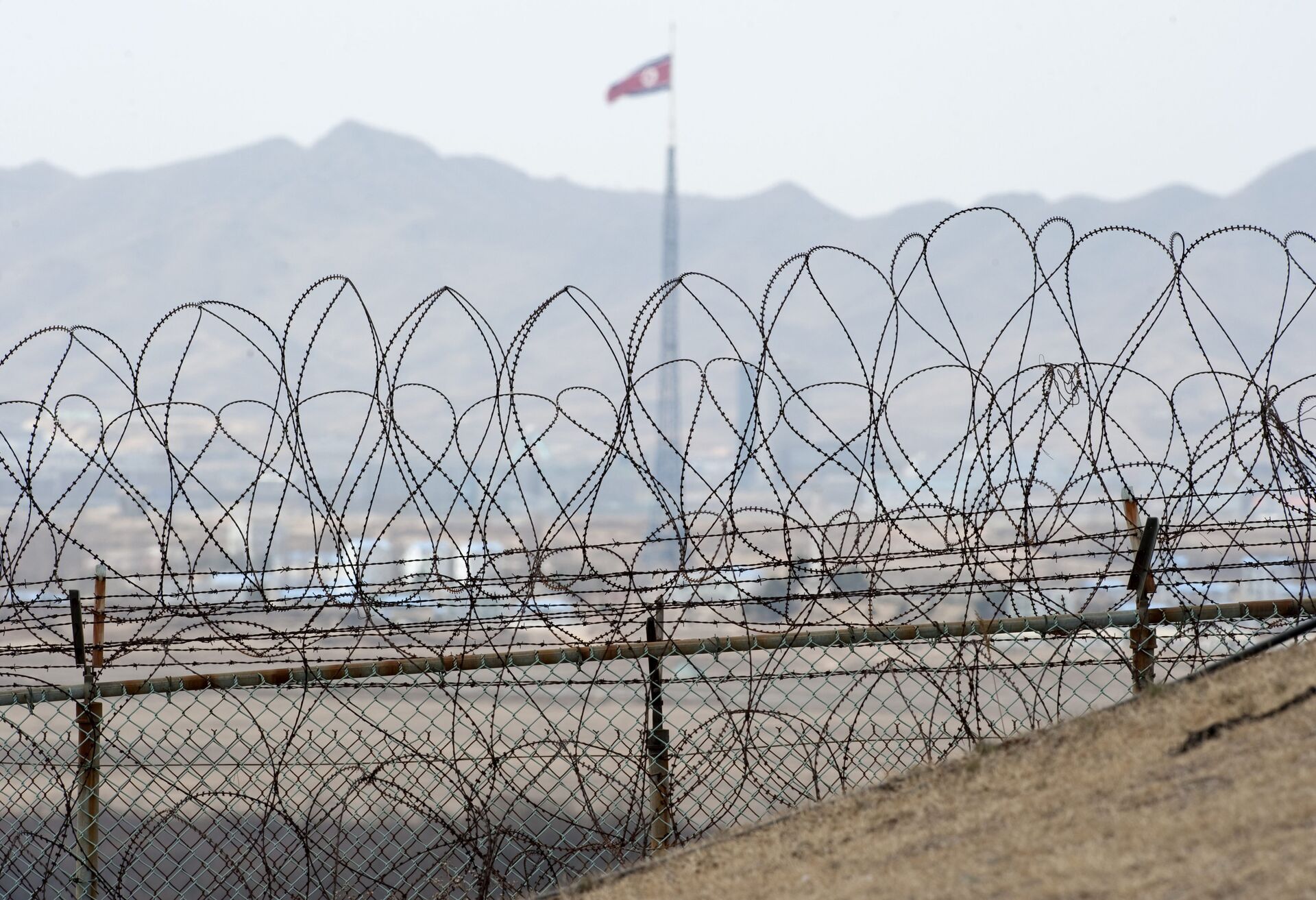 A North Korean flag behind the barbed wire of the Demilitarized Zone (DMZS) in the Joint Security Area near Panmunjom on the border between North and South Korea - Sputnik International, 1920, 04.11.2021