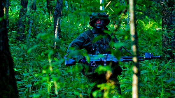 An infantryman, with the Grand Dutches Birute Uhlan Battalion, Lithuanian Armed Forces, patrols the woods for mock enemy troops during exercise Saber Strike, at a training area near Rukla, Lithuania June 15, 2015 - Sputnik International