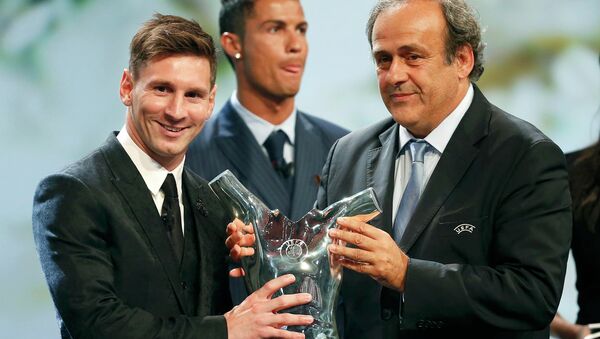 Barcelona's Lionel Messi (L) receives from UEFA President Michel Platini the Best Player UEFA 2015 Award during the draw ceremony for the 2015/2016 Champions League Cup soccer competition at Monaco's Grimaldi Forum while Cristiano Ronaldo (C) looks on in Monte Carlo August 27, 2015 - Sputnik International