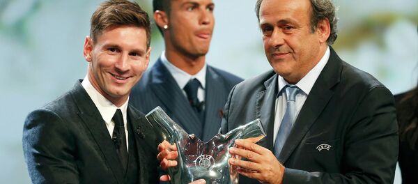 Barcelona's Lionel Messi (L) receives from UEFA President Michel Platini the Best Player UEFA 2015 Award during the draw ceremony for the 2015/2016 Champions League Cup soccer competition at Monaco's Grimaldi Forum while Cristiano Ronaldo (C) looks on in Monte Carlo August 27, 2015 - Sputnik International