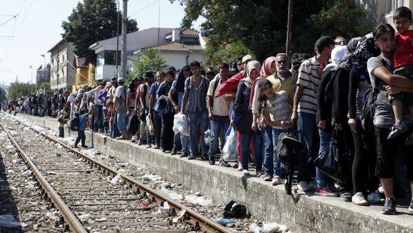 Migrants line up to board a train that would take them towards Serbia, at the railway station in the southern Macedonian town of Gevgelija, on Monday, Aug. 17, 2015 - Sputnik International