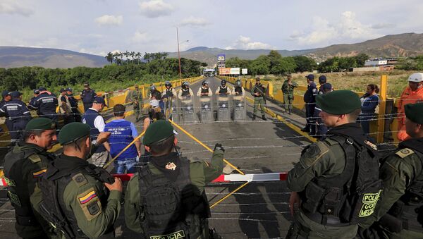 Colombian policemen stand guard in front of the border with Venezuelan policemen Bolivarianos near Villa del Rosario village, August 27, 2015 - Sputnik International