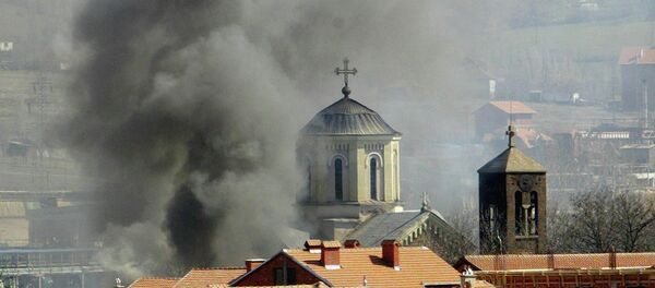 Smoke billows from Serbian Orthodox Church which was set ablaze by ethnic Albanian extremists in the northern Kosovo city of Kosovska Mitrovica, Thursday, March 18, 2004 - Sputnik International