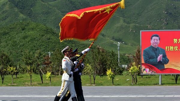 Chinese flag bearers practice marching near a portrait of Chinese President Xi Jinping ahead of a Sept. 3 military parade. - Sputnik International