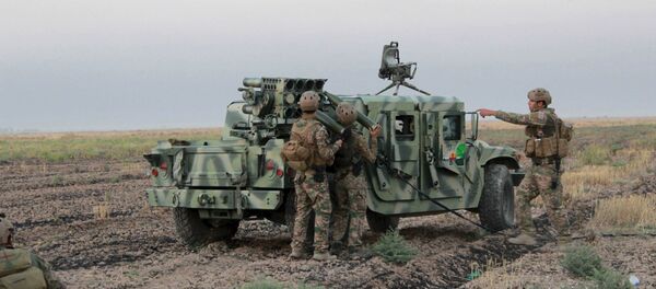 Kurdish Peshmerga fighters reload a weapon during clashes with Islamic State militants south of Daquq, north of Baghdad August 26, 2015 - Sputnik International
