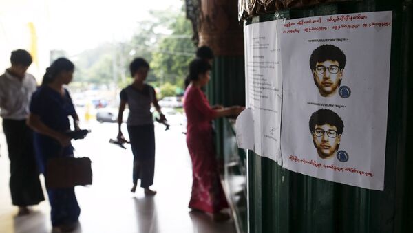 People line up as they leave their slippers near a wanted poster for the main suspect of a deadly bomb blast in Bangkok, Thailand, put up by local authorities at Shwedagon pagoda in Yangon, Myanmar August 25, 2015 - Sputnik International