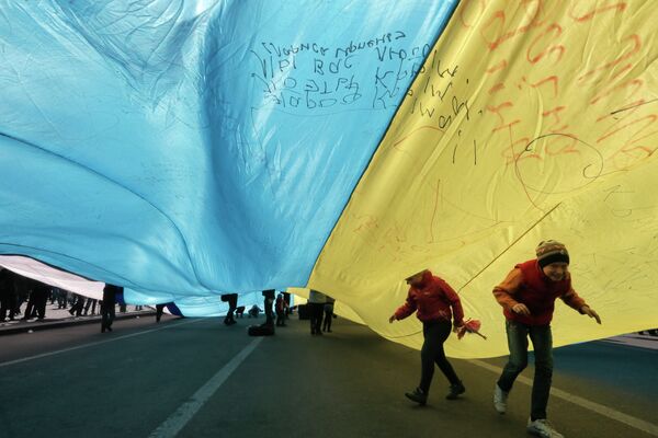Ukrainian kids play under a huge yellow-and-blue Ukrainian national flag at a rally in Kiev's Independent square, Ukraine, Saturday, April 5, 2014 Ukrainian kids play under a huge yellow-and-blue Ukrainian national flag at a rally in Kiev's Independent square, Ukraine, Saturday, April 5, 2014 - Sputnik International