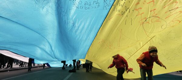 Ukrainian kids play under a huge yellow-and-blue Ukrainian national flag at a rally in Kiev's Independent square, Ukraine, Saturday, April 5, 2014 Ukrainian kids play under a huge yellow-and-blue Ukrainian national flag at a rally in Kiev's Independent square, Ukraine, Saturday, April 5, 2014 - Sputnik International