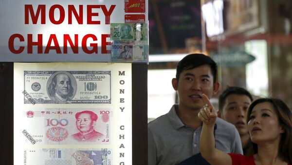 People look at the exchange rate at a moneychanger displaying a poster of U.S. dollar bill, Chinese Yuan and Malaysia Ringgit in Singapore - Sputnik International