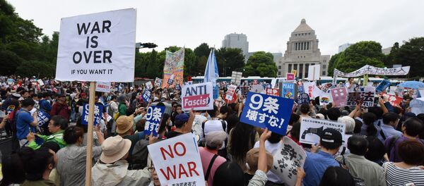 People shout slogans as they hold banners during an anti-government rally in front of the National Diet in Tokyo - Sputnik International
