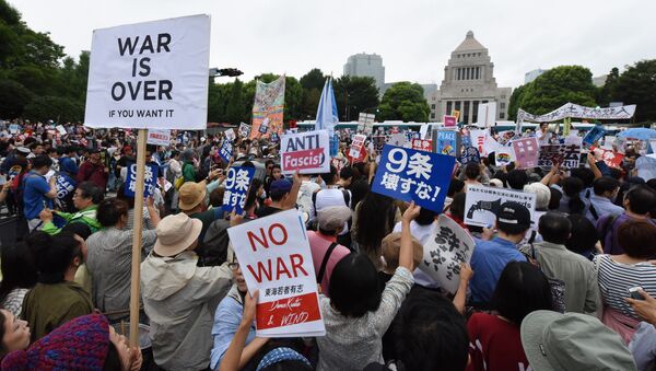 People shout slogans as they hold banners during an anti-government rally in front of the National Diet in Tokyo - Sputnik International