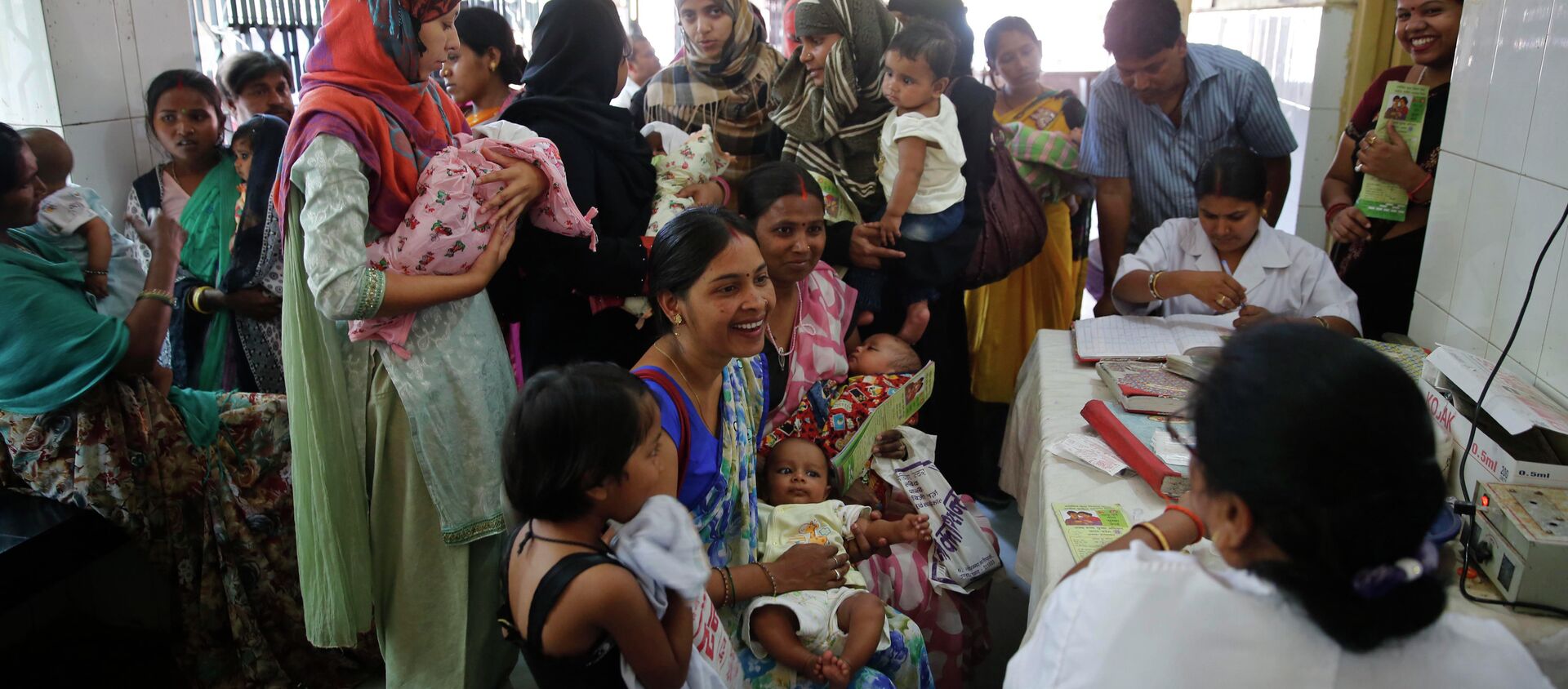 Indian women wait to get their infants immunized as part of  an immunization drive at a government hospital in Allahabad, India. - Sputnik International, 1920, 31.08.2015