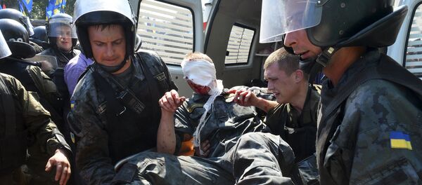Ukrainian national guard officers carry an injured comrade on a stretcher outside the parliament building in Kiev, Ukraine, August 31, 2015 Ukrainian national guard officers carry an injured comrade on a stretcher outside the parliament building in Kiev, Ukraine, August 31, 2015 - Sputnik International