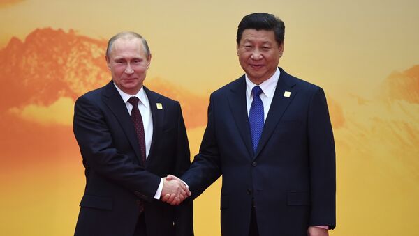 Russia's President Vladimir Putin (L) shakes hands with China's President Xi Jinping - Sputnik International
