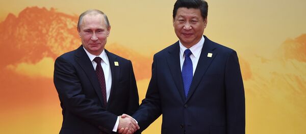 Russia's President Vladimir Putin (L) shakes hands with China's President Xi Jinping - Sputnik International