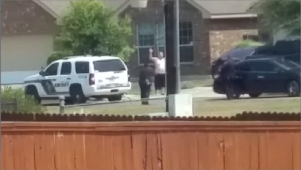 Cell phone video aired by KSAT shows Gilbert Flores standing outside of his San Antonio home Friday during a domestic violence call. In the video, Flores, 41, raises his hands over his head then suddenly collapses to the ground after he is apparently shot by deputies. - Sputnik International