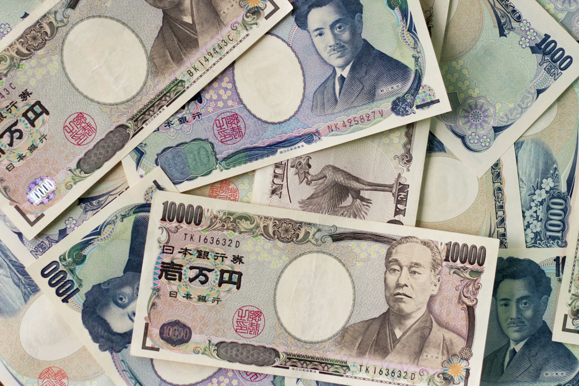 1000 yen bills and 10,000 yen bills spread out on a table. - Sputnik International, 1920, 21.10.2022