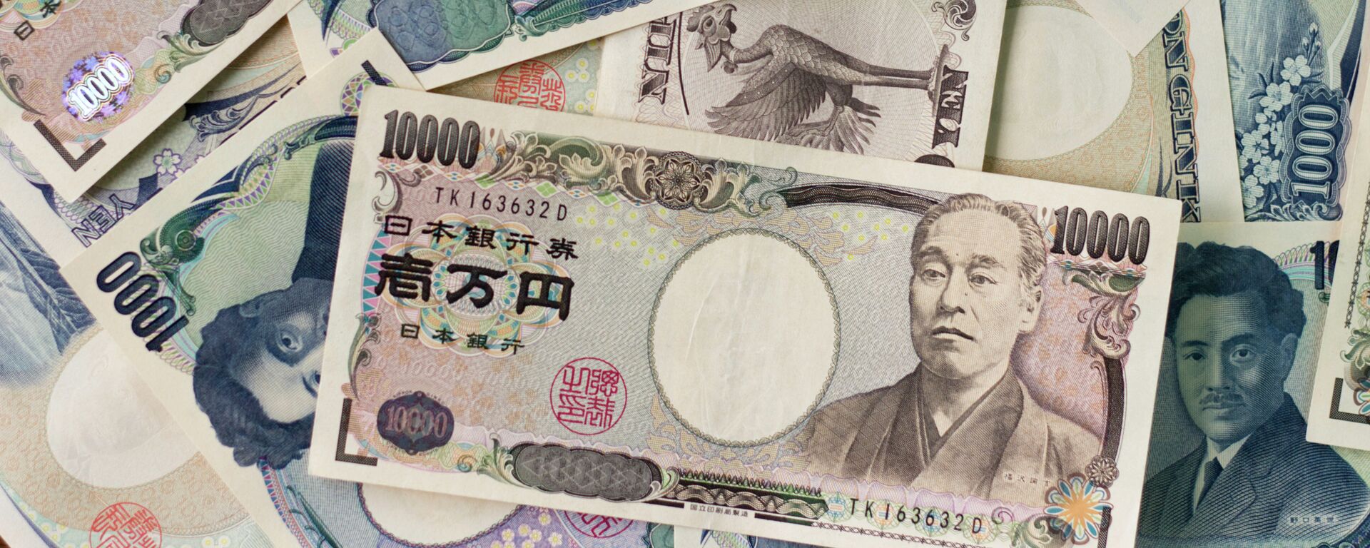 1000 yen bills and 10,000 yen bills spread out on a table. - Sputnik International, 1920, 19.10.2022