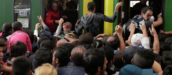 A young child cries as hundreds of migrants try to board a train at the Keleti Railway Station in Budapest, Hungary, Thursday, Sept. 3, 2015 - Sputnik International