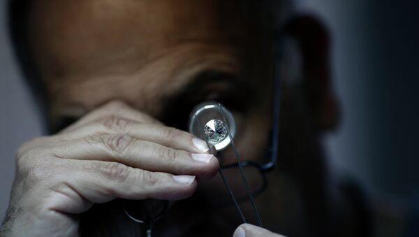 An Israeli diamonds buyer checks the quality of a diamond during the International Diamond Week (IDW) on February 10, 2015 in the Israeli city of Ramat Gan, east of Tel Aviv. - Sputnik International