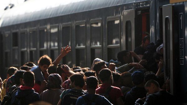 Migrants storm into a train at the Keleti train station in Budapest, Hungary, September 3, 2015 as Hungarian police withdrew from the gates after two days of blocking their entry - Sputnik International