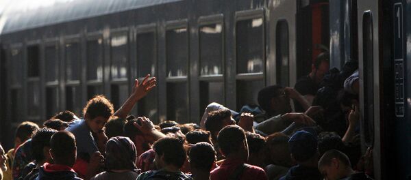 Migrants storm into a train at the Keleti train station in Budapest, Hungary, September 3, 2015 as Hungarian police withdrew from the gates after two days of blocking their entry Migrants storm into a train at the Keleti train station in Budapest, Hungary, September 3, 2015 as Hungarian police withdrew from the gates after two days of blocking their entry - Sputnik International