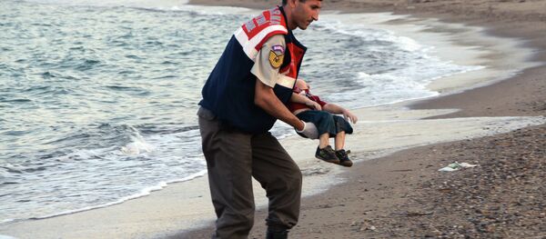 A migrant child's dead body lies off the shores in Bodrum, southern Turkey, on September 2, 2015 after a boat carrying refugees sank while reaching the Greek island of Kos. A migrant child's dead body lies off the shores in Bodrum, southern Turkey, on September 2, 2015 after a boat carrying refugees sank while reaching the Greek island of Kos. - Sputnik International