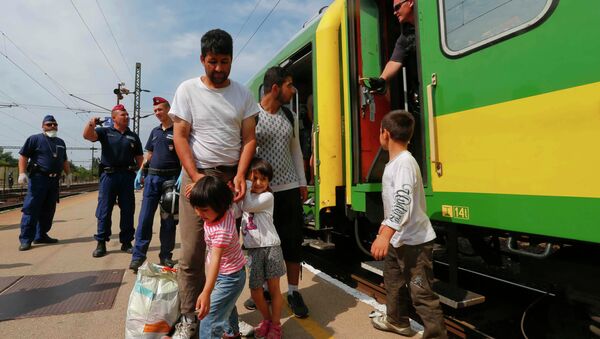 Migrants stand outside a train at the railway station in the town of Bicske, Hungary, September 3, 2015 - Sputnik International